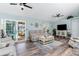 Spacious living room with hardwood floors, comfortable seating, and a view to the pool at 13511 Foresman Blvd, Port Charlotte, FL 33981