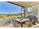 Relaxing screened patio with table, chairs, and grill, overlooking a lush green landscape at 13534 Eagle Pointe Dr, Port Charlotte, FL 33953