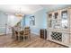Bright dining room with hardwood floors, chandelier, and built-in wine storage at 10055 Links Ln # 206, Rotonda West, FL 33947