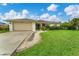 Front view of a single-story home, highlighting the landscaping and driveway at 2555 Dixon Ter, Port Charlotte, FL 33981