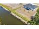 A waterfront home boasts a dark roof, sits along a picturesque canal, and lush greenery surrounds the area at 220 Mark Twain Ln, Rotonda West, FL 33947