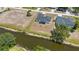 A waterfront home boasts a dark roof, sits along a picturesque canal, and lush greenery surrounds the area at 220 Mark Twain Ln, Rotonda West, FL 33947