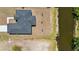 A waterfront home boasts a dark roof, sits along a picturesque canal, and lush greenery surrounds the area at 220 Mark Twain Ln, Rotonda West, FL 33947
