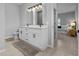 Bright bathroom with double vanity, sleek fixtures, and doorway view to the bedroom at 220 Mark Twain Ln, Rotonda West, FL 33947