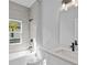 Contemporary bathroom with tub, shower, and a sink with modern black faucet at 220 Mark Twain Ln, Rotonda West, FL 33947
