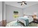 Light-filled bedroom with ceiling fan, large window and nature-themed area rug at 220 Mark Twain Ln, Rotonda West, FL 33947