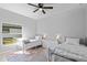 Cozy bedroom with two beds, ceiling fan, and natural light from the large window at 220 Mark Twain Ln, Rotonda West, FL 33947