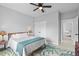 Comfortable bedroom featuring a ceiling fan, nature-themed area rug and a well-lit closet at 220 Mark Twain Ln, Rotonda West, FL 33947
