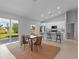 Bright open-concept dining area with a modern kitchen, breakfast bar and a sliding glass door to the backyard at 220 Mark Twain Ln, Rotonda West, FL 33947