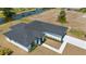 New construction single-Gathering home with a black roof, white walls, and a canal view at 220 Mark Twain Ln, Rotonda West, FL 33947