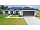 Charming single-story home showcasing a modern design with a gray roof, lawn, and a gray two-car garage at 220 Mark Twain Ln, Rotonda West, FL 33947
