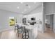 Modern kitchen featuring white cabinets, stainless appliances and a large island with bar stool seating at 220 Mark Twain Ln, Rotonda West, FL 33947