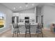 Bright kitchen with white cabinets, quartz countertops, island seating, and stainless steel appliances at 220 Mark Twain Ln, Rotonda West, FL 33947
