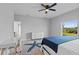 Bright bedroom with ceiling fan, view of backyard and en suite bath at 220 Mark Twain Ln, Rotonda West, FL 33947