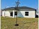 This backyard has an open lawn, a small patio area, and a young tree recently planted at 235 Albatross Rd, Rotonda West, FL 33947