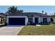 Charming one-story home with dark gray roof, black trim, and a well-manicured lawn at 235 Albatross Rd, Rotonda West, FL 33947