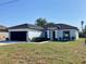 Attractive one-story house with dark gray roof, black trim, and green lawn at 235 Albatross Rd, Rotonda West, FL 33947
