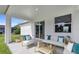Comfortable outdoor patio featuring modern furniture, bright pillows, and a sliding glass door to the home's interior at 235 Albatross Rd, Rotonda West, FL 33947