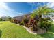Landscaped backyard with a screened enclosure and tropical plants at 240 White Marsh Ln, Rotonda West, FL 33947
