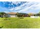 Backyard view of home with spacious lawn and screened patio at 240 White Marsh Ln, Rotonda West, FL 33947