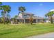 Two-story home with gray siding, blue shutters, and lush landscaping at 61 Pinehurst Pl, Rotonda West, FL 33947