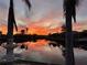 Stunning sunset over calm canal waters with palm trees and waterfront homes at 9325 St Paul Dr, Port Charlotte, FL 33981