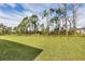 Large backyard with grassy area, trees and a partly sunny day at 14194 Wenzel Ave, Port Charlotte, FL 33981