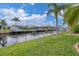 Landscaped canal-front yard with lush greenery and dock access at 2517 Rio Grande Dr, Punta Gorda, FL 33950