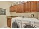 Laundry room with wood cabinets and matching washer and dryer at 2517 Rio Grande Dr, Punta Gorda, FL 33950