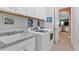 Bright laundry room with white cabinets, granite countertops, and a utility sink at 15248 Spanish Point Dr, Port Charlotte, FL 33981