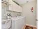 Laundry room with washer, dryer, and extra storage cabinets at 3195 Village Ln, Port Charlotte, FL 33953