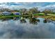 Aerial view of lakefront homes and reflecting trees at 3195 Village Ln, Port Charlotte, FL 33953