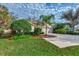 Landscaped front yard with lush greenery and a paved driveway at 3195 Village Ln, Port Charlotte, FL 33953