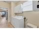 Bright laundry room with washer, dryer, and cabinets. Kitchen view at 1033 Yosemite Dr, Englewood, FL 34223