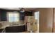 Small kitchen with dark cabinets, refrigerator, and window at 1700 Morning Dove Ln, Englewood, FL 34224