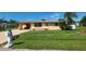 Cute yellow house with a well-maintained lawn at 1700 Morning Dove Ln, Englewood, FL 34224