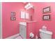 Pink bathroom with white vanity, toilet and shower/tub combo at 1384 Backspin Dr, Englewood, FL 34223