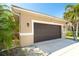 Attached garage with dark brown door and landscaping at 4632 Arlington Dr, Placida, FL 33946