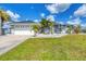 Gray house with a three car garage and palm trees at 13400 Buckett Cir, Port Charlotte, FL 33981