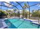 Inviting screened pool with tiled deck and fountain feature at 13400 Buckett Cir, Port Charlotte, FL 33981