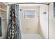 Simple bathroom with shower/tub, window and patterned curtain at 25 1St Ave, Englewood, FL 34223