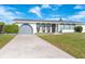 Charming single story home with grey garage door and manicured lawn at 20 Annapolis Ln, Rotonda West, FL 33947