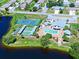 Aerial view of community pool, tennis court, shuffleboard, and lake at 612 Deerwood Ave # 169, Englewood, FL 34223