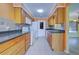 Kitchen with wood cabinets, dark counters, and appliances at 612 Deerwood Ave # 169, Englewood, FL 34223