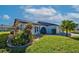 Single-story home with light blue exterior, landscaping, and palm trees at 612 Deerwood Ave # 169, Englewood, FL 34223