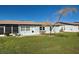Back of house with light blue exterior, small patio, and landscaping at 612 Deerwood Ave # 169, Englewood, FL 34223