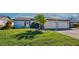 Front view of a light blue house with a palm tree and two-car garage at 612 Deerwood Ave # 169, Englewood, FL 34223