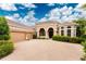 Two-story house with a three-car garage, brick driveway, and lush landscaping at 10 Boca Royale Blvd, Englewood, FL 34223