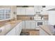 White kitchen with stainless steel appliances and a breakfast nook at 13313 Gasparilla Rd # C205, Placida, FL 33946