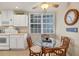 Charming breakfast nook with glass-top table and four wicker chairs at 13313 Gasparilla Rd # C205, Placida, FL 33946